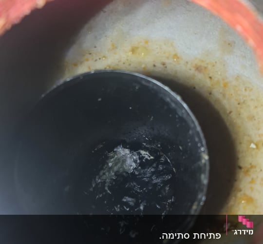 מבט אל פנים צינור ניקוז סתום עם מים עומדים ולכלוך
